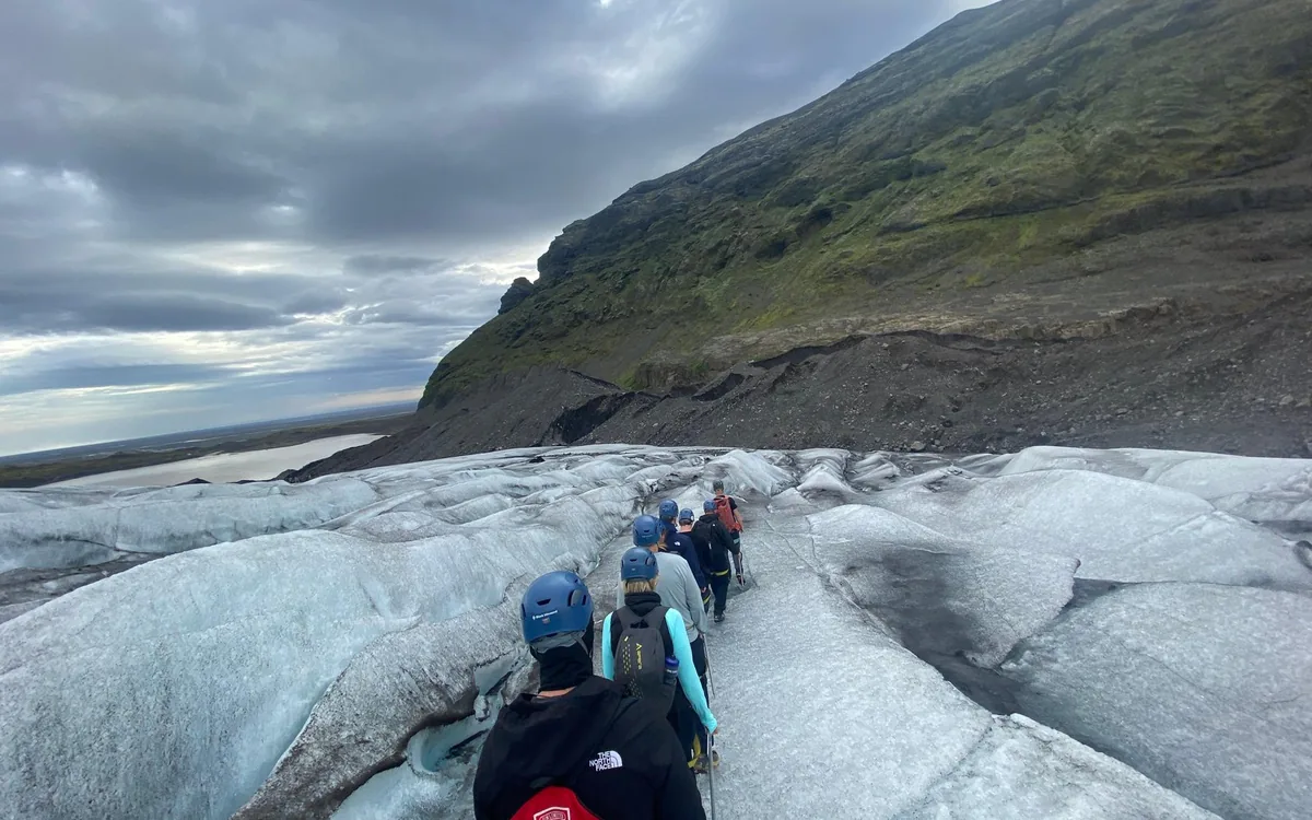 Crampons strapped over a boot on the blue ice of an Icelandic glacier