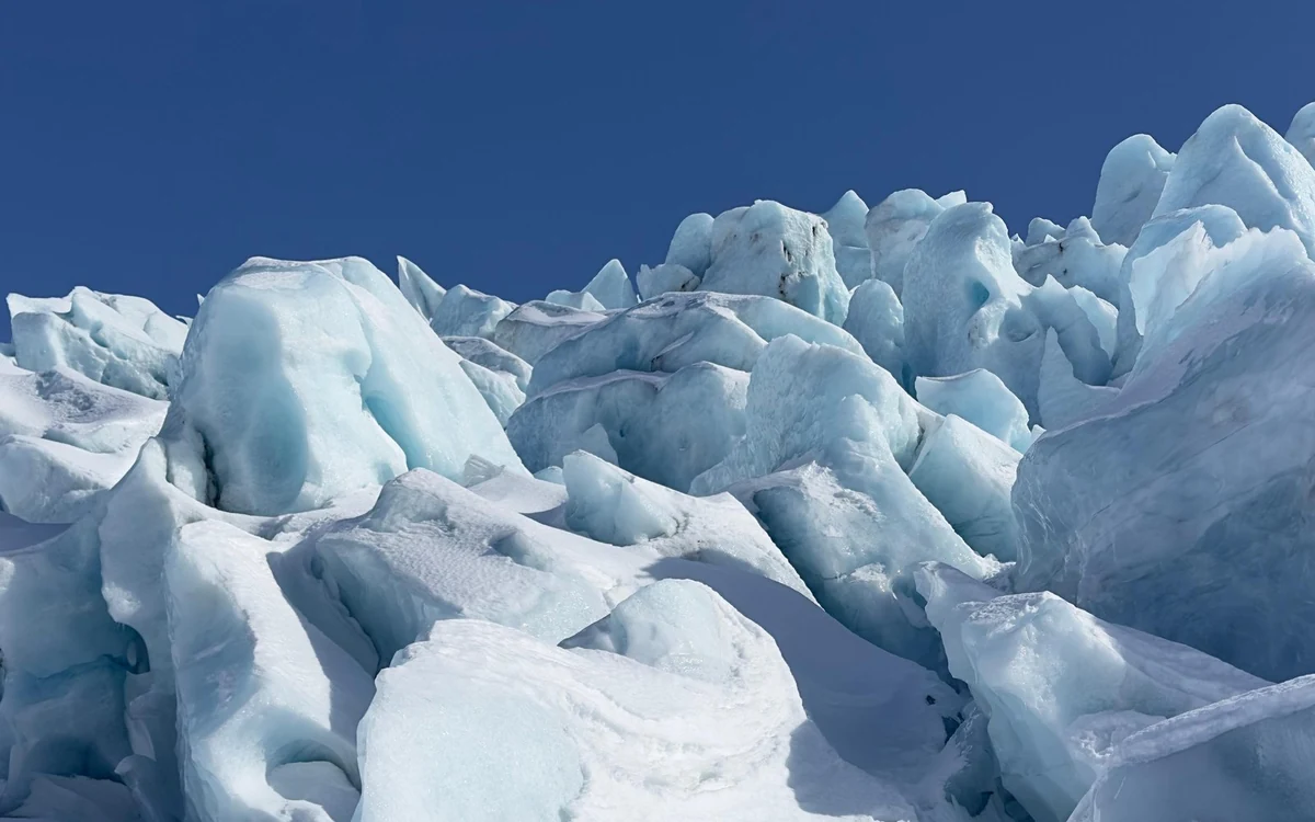 A guided group walking the ice of Sólheimajökull in crampons
