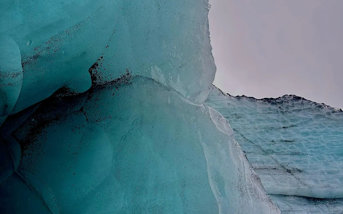 A guided group in crampons crossing blue glacier ice in Iceland
