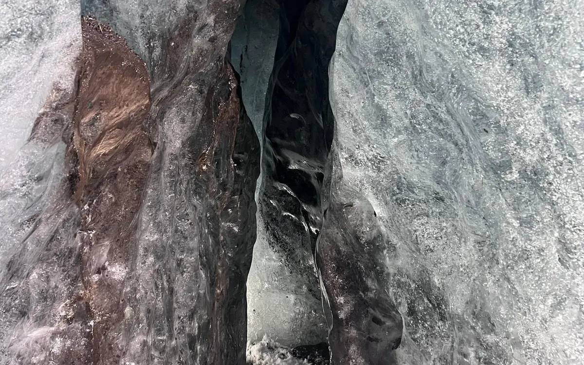 A visitor inside a blue ice cave on Vatnajökull