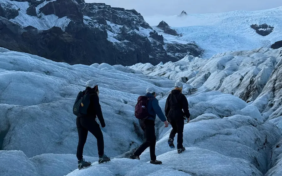 A guide and two walkers alone on Sólheimajökull glacier