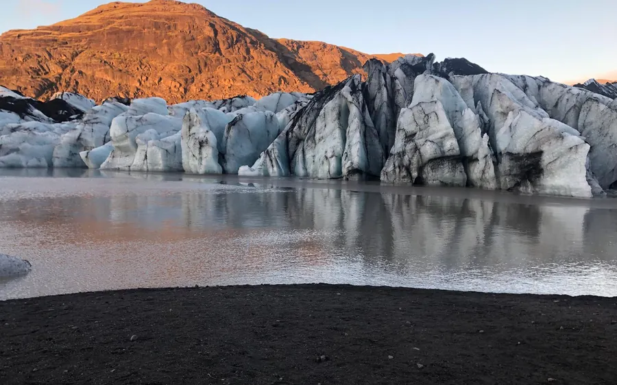 Walkers crossing the ash-streaked ice of Sólheimajökull